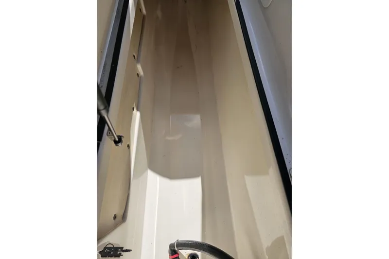 Slide: The Image of Interior view of a 2017 Yamaha Boats 242X E-Series, showcasing storage compartment. - 76