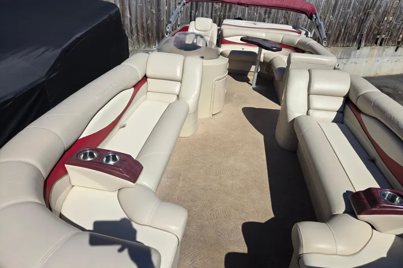 Slide: The Image of 2010 Bennington 2275RLi pontoon boat interior with beige seating and cup holders. - 4