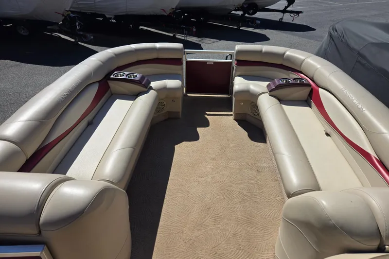Slide: The Image of 2010 Bennington 2275RLi pontoon boat interior with beige seating and cup holders. - 5