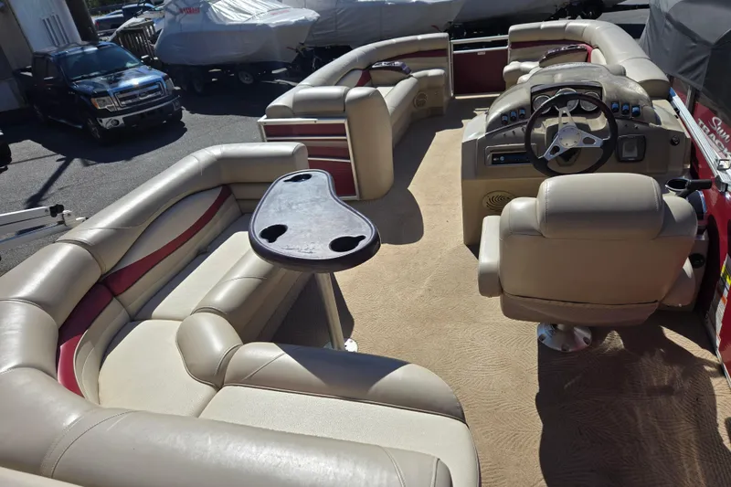 Slide: The Image of 2010 Bennington 2275RLi pontoon boat interior with plush seating and steering console. - 6