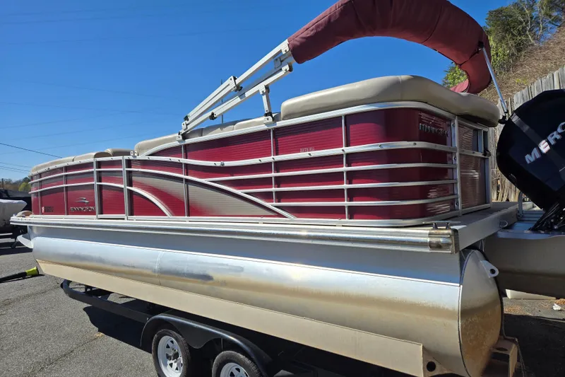 Slide: The Image of 2010 Bennington 2275RLi pontoon boat on trailer, featuring red and beige design. - 9