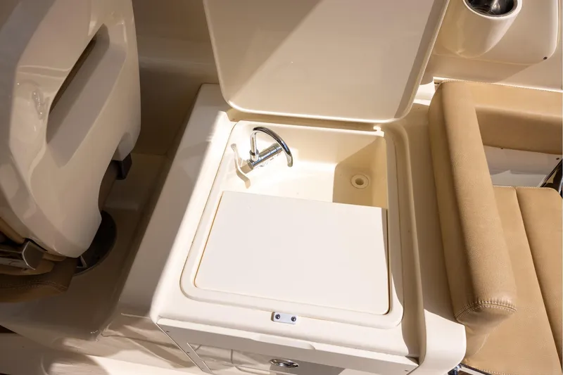 Slide: The Image of 2018 Scout 275 Dorado boat sink and seating area, featuring beige upholstery. - 12