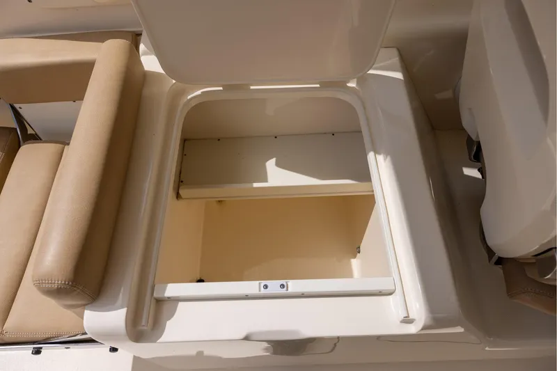 Slide: The Image of Open storage compartment on 2018 Scout 275 Dorado boat with beige seating. - 13