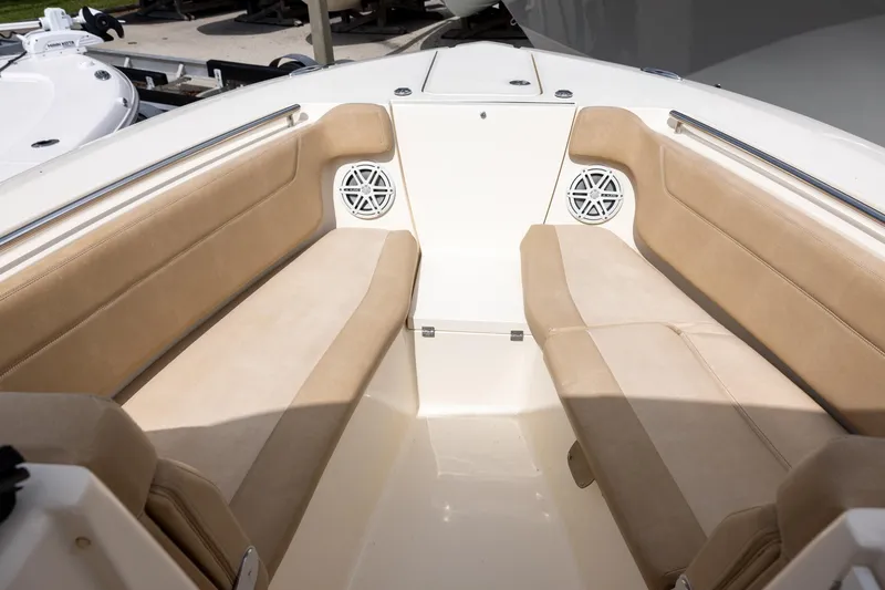 Slide: The Image of Interior seating of a 2018 Scout 275 Dorado boat with beige cushions and speakers. - 18