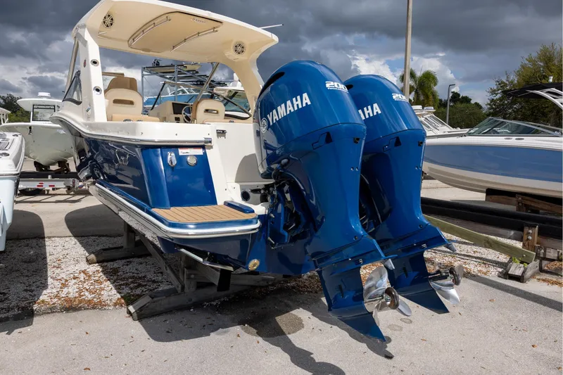 Slide: The Image of 2018 Scout 275 Dorado boat with twin Yamaha 200 engines, docked under cloudy skies. - 3