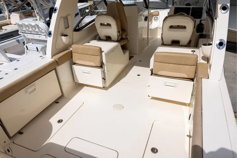 Slide: The Image of 2018 Scout 275 Dorado boat interior with beige seating and storage compartments. - 5