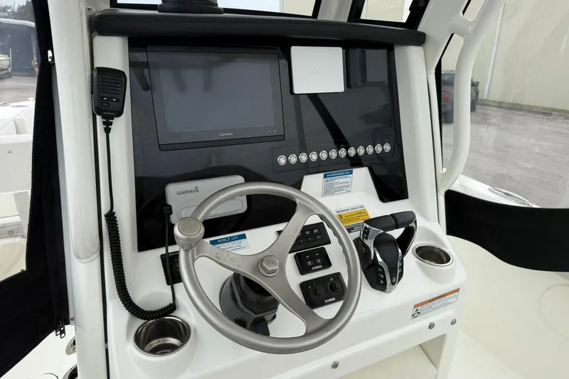 Slide: The Image of 2025 World Cat 235 TE boat dashboard with Garmin display and steering wheel. - 18