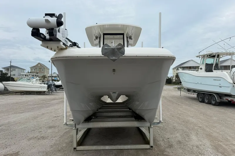 Slide: The Image of 2025 World Cat 235 TE boat on trailer, front view, in a marina setting. - 7