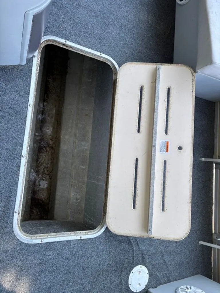 Slide: The Image of Open storage compartment on a 2011 G3 SunCatcher boat. - 12