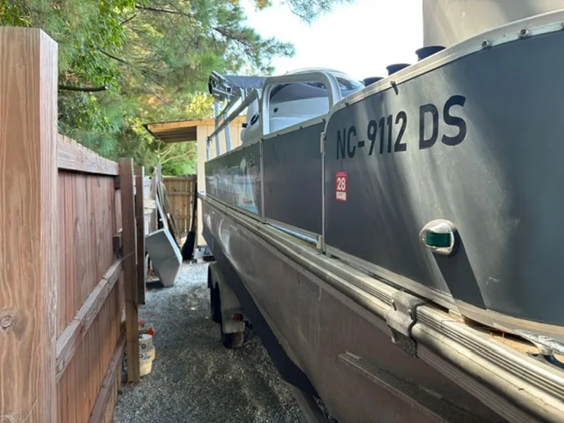 Slide: The Image of 2011 G3 SunCatcher boat parked beside wooden fence. - 9