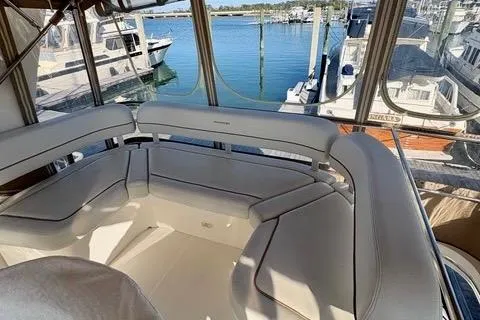 Slide: The Image of 2008 Silverton 36 Convertible yacht interior with white seating, docked at a marina. - 17