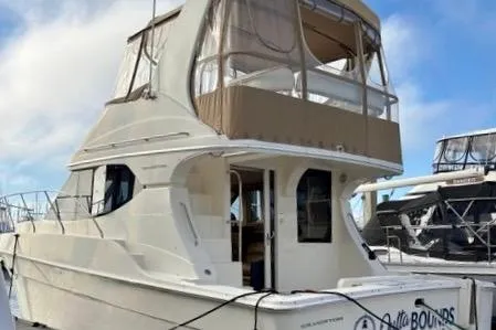 Slide: The Image of 2008 Silverton 36 Convertible yacht docked at marina under blue sky. - 2
