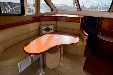 Slide: The Image of 2008 Silverton 36 Convertible yacht interior with beige seating and wooden table. - 20
