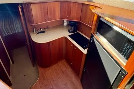 Slide: The Image of 2008 Silverton 36 Convertible yacht kitchen with wood cabinetry and modern appliances. - 22