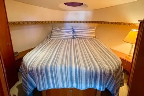 Slide: The Image of Cozy bedroom in 2008 Silverton 36 Convertible yacht with striped bedding and warm lighting. - 27