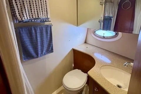 Slide: The Image of 2008 Silverton 36 Convertible yacht bathroom with sink, toilet, and porthole window. - 29