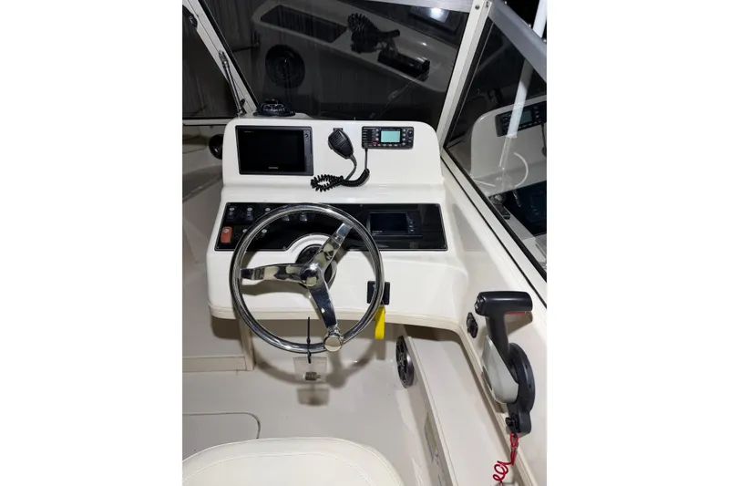 Slide: The Image of 2020 Grady White Freedom 192 boat dashboard with steering wheel and navigation controls. - 18
