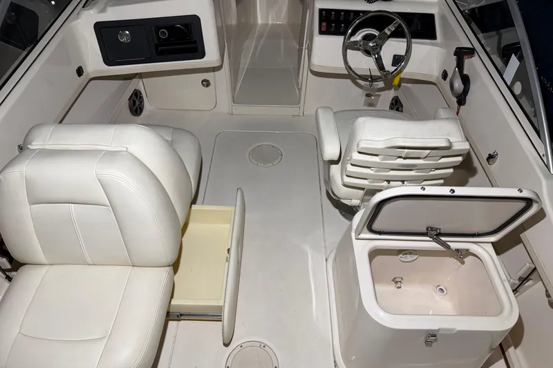 Slide: The Image of 2020 Grady White Freedom 192 boat interior with white seating and steering console. - 9