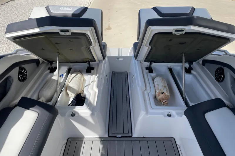 Slide: The Image of 2021 Yamaha Boats 275SE storage compartments open, showcasing interior space and seating. - 15