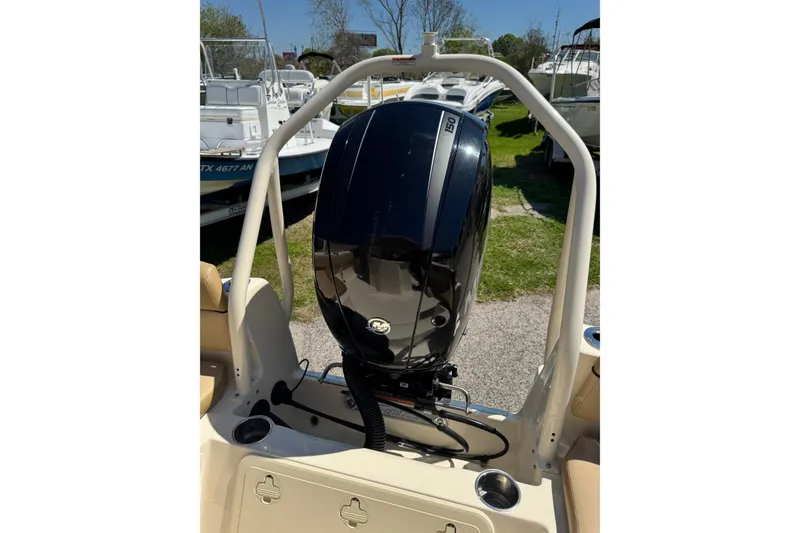 Slide: The Image of 2018 Scout 195 Sportfish boat with powerful outboard motor in a marina setting. - 16