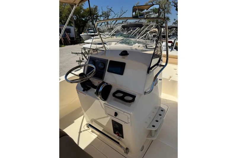 Slide: The Image of 2018 Scout 195 Sportfish boat console with steering wheel and controls. - 18