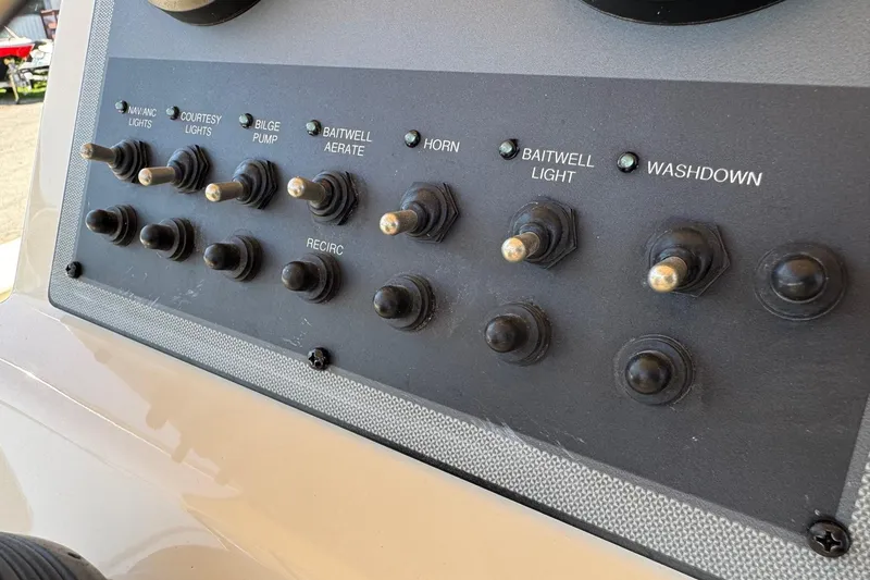 Slide: The Image of Control panel of a 2018 Scout 195 Sportfish boat with various switches. - 22