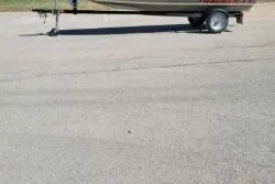 Slide: The Image of 2025 Tracker Grizzly 1436 Utility boat on trailer in parking lot. - 3