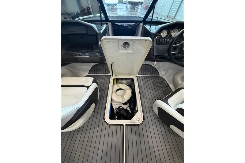 Slide: The Image of 2016 Monterey 224FS boat interior with open storage compartment and sleek dashboard. - 15