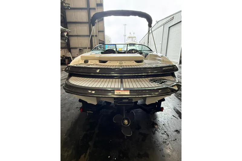 Slide: The Image of Rear view of a 2016 Monterey 224FS boat in a warehouse setting. - 6