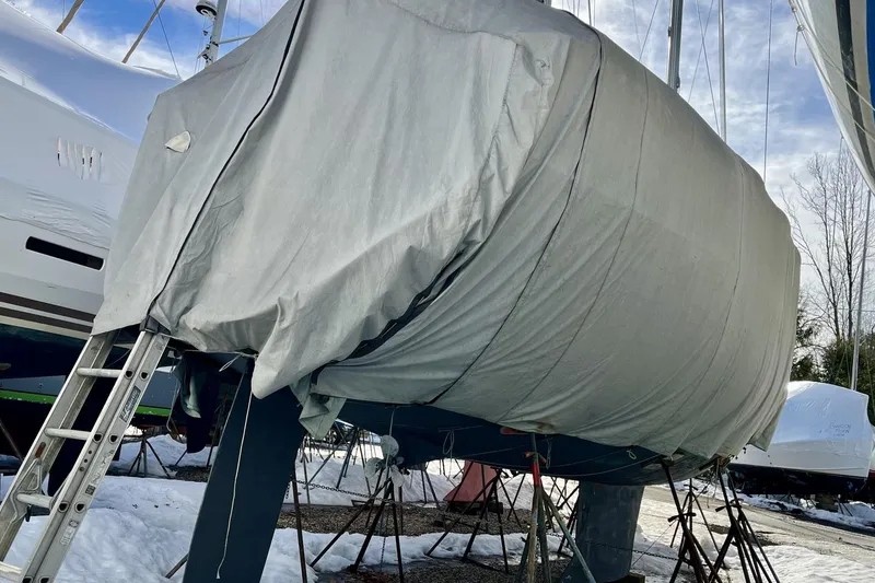 Slide: The Image of Covered 1999 Beneteau Oceanis 381 sailboat on stands in a snowy yard. - 10