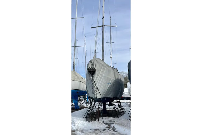 Slide: The Image of 1999 Beneteau Oceanis 381 sailboat covered and stored on land in snowy conditions. - 12