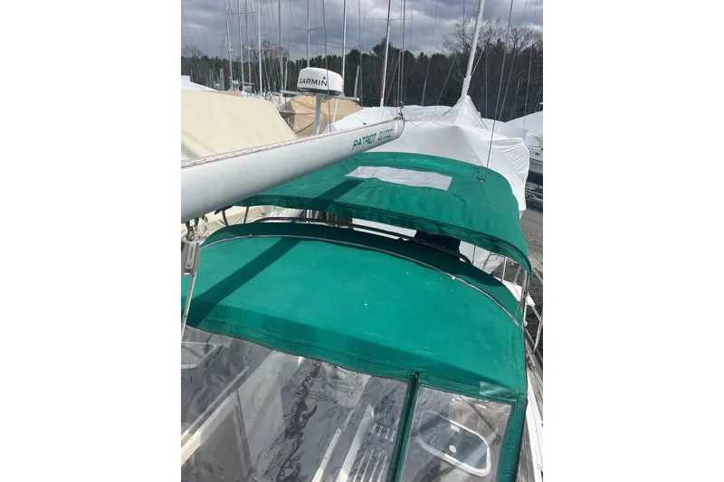 Slide: The Image of 1999 Beneteau Oceanis 381 sailboat with green canopy, docked in a marina. - 16