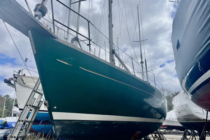 Slide: The Image of 1999 Beneteau Oceanis 381 sailboat on land, surrounded by other boats, under cloudy sky. - 17