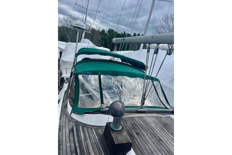 Slide: The Image of 1999 Beneteau Oceanis 381 sailboat with green canopy and wooden deck, docked outdoors. - 19