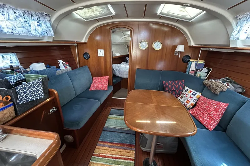 Slide: The Image of Cozy interior of 1999 Beneteau Oceanis 381 sailboat with wooden finishes and colorful cushions. - 2