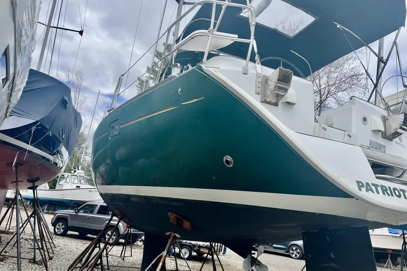 Slide: The Image of 1999 Beneteau Oceanis 381 sailboat on stands, green hull, overcast sky background. - 24