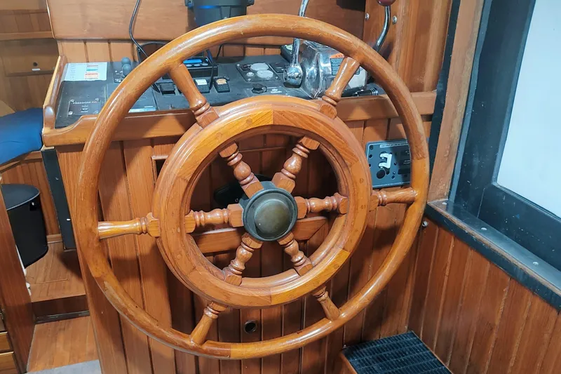 Slide: The Image of Wooden steering wheel on a 1986 CHB Senator boat, showcasing classic nautical design. - 23