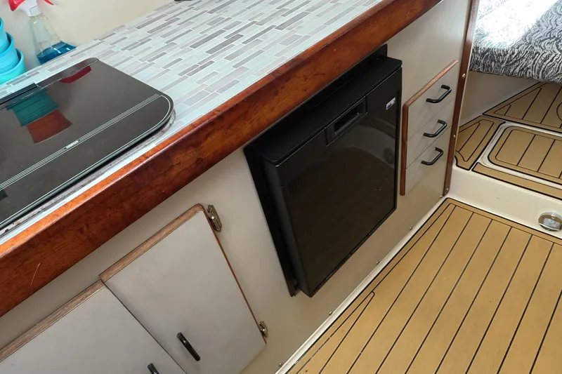 Slide: The Image of Interior of a 1992 Luhrs 300 Tournament boat with kitchenette and wood flooring. - 9
