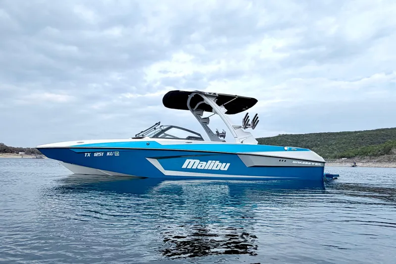 The Image of 2023 Malibu Wakesetter 23 MXZ boat on calm water under cloudy sky. - 1