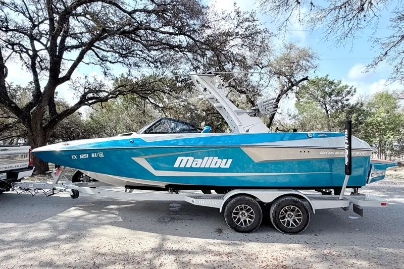 Slide: The Image of 2023 Malibu Wakesetter 23 MXZ boat on trailer, parked outdoors. - 15