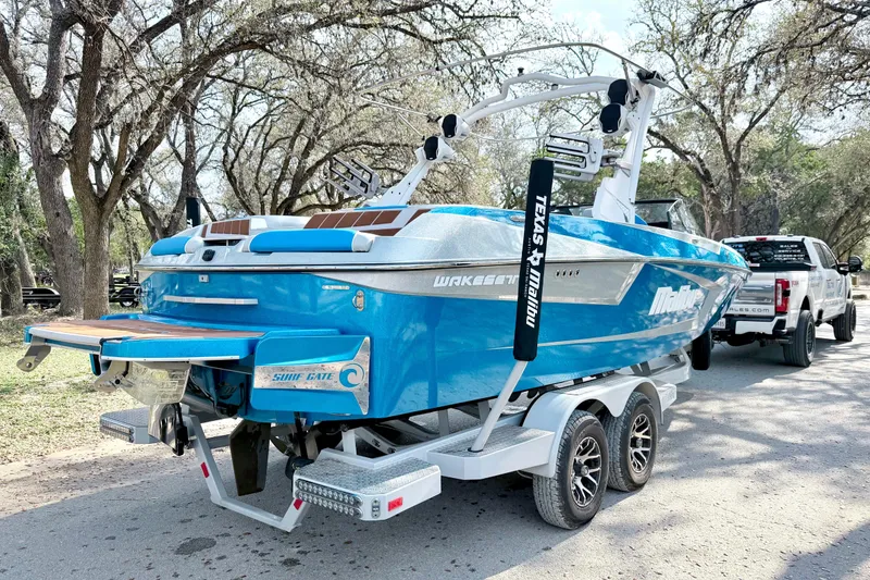 Slide: The Image of 2023 Malibu Wakesetter 23 MXZ boat on trailer, parked outdoors. - 19