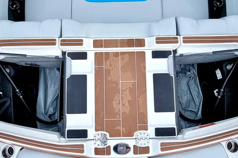 Slide: The Image of 2023 Malibu Wakesetter 23 MXZ boat interior with storage compartments and teak-style flooring. - 26