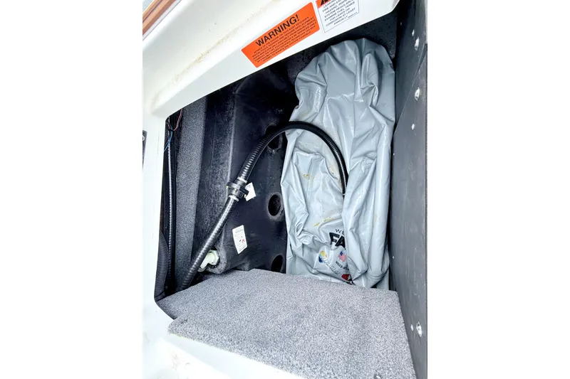 Slide: The Image of 2023 Malibu Wakesetter 23 MXZ ballast compartment with hose and warning label. - 27