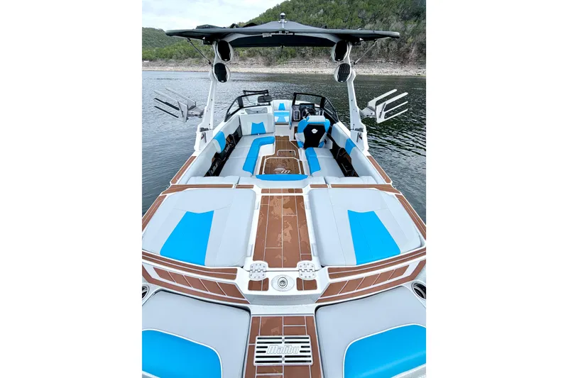 Slide: The Image of 2023 Malibu Wakesetter 23 MXZ boat with blue and white interior on a lake. - 28