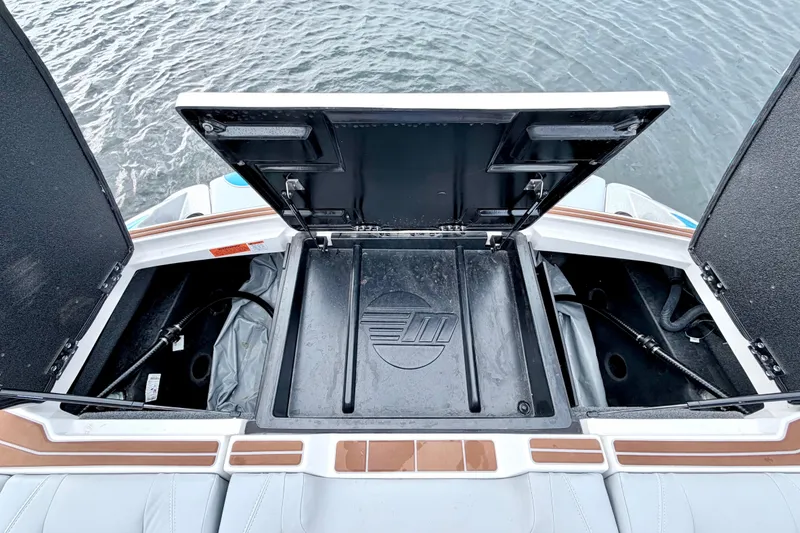 Slide: The Image of 2023 Malibu Wakesetter 23 MXZ storage compartment open on a boat, near water. - 30