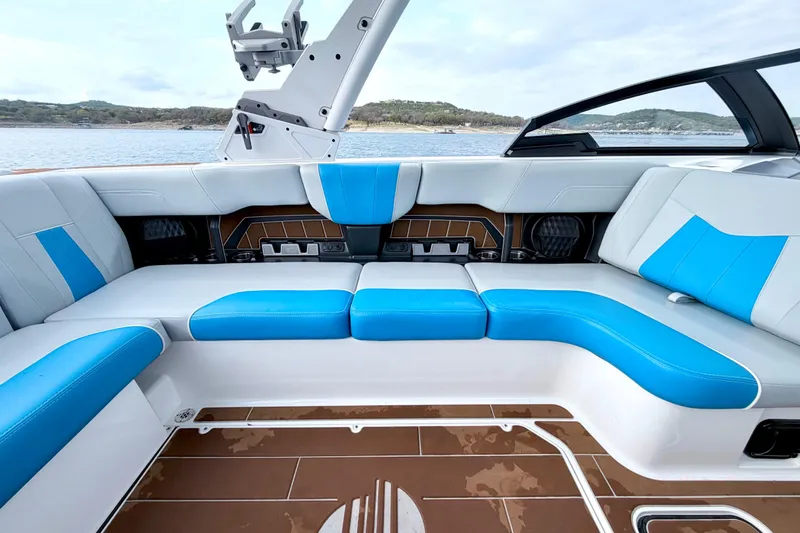 Slide: The Image of 2023 Malibu Wakesetter 23 MXZ interior with blue and white seating, lake view. - 33