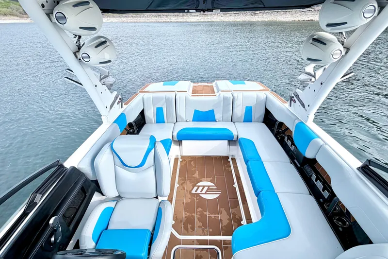 Slide: The Image of 2023 Malibu Wakesetter 23 MXZ interior with blue and white seating on a lake. - 37