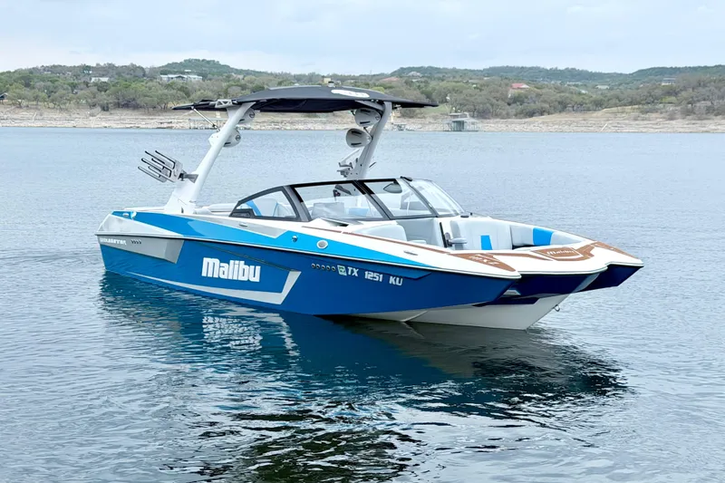 Slide: The Image of 2023 Malibu Wakesetter 23 MXZ boat on calm lake waters. - 6