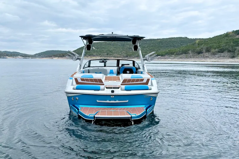 Slide: The Image of 2023 Malibu Wakesetter 23 MXZ on a serene lake with scenic hills. - 7