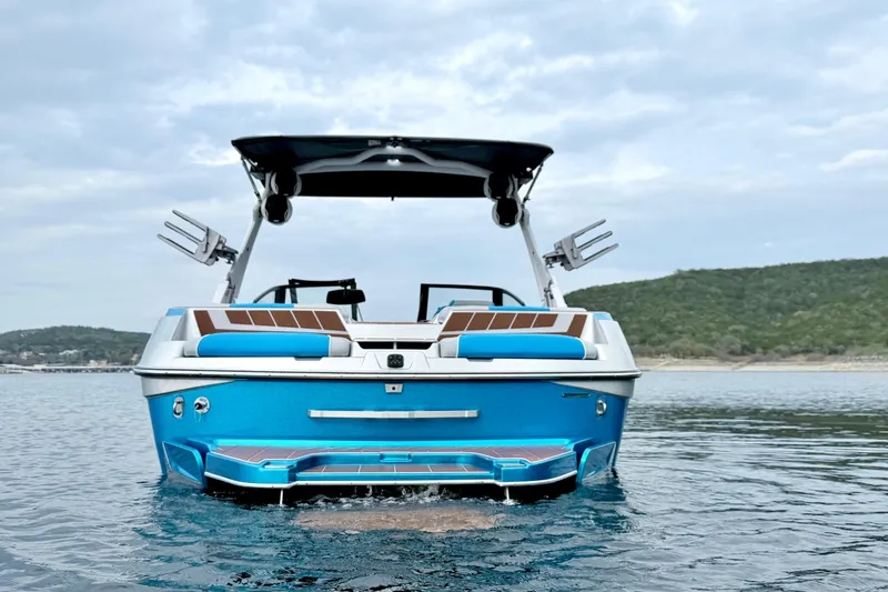 Slide: The Image of 2023 Malibu Wakesetter 23 MXZ on water, showcasing sleek design and vibrant blue color. - 8